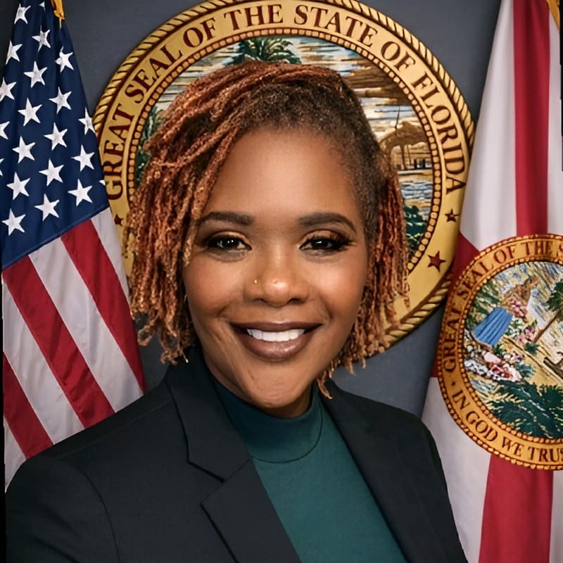 Laurinda Lala Andujar smiling in front of the Florida state flag